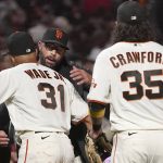 
              San Francisco Giants manager Gabe Kapler, middle, celebrates with LaMonte Wade Jr. (31) and Brandon Crawford (35) after the Giants defeated the San Diego Padres in a baseball game to clinch a postseason berth in San Francisco, Monday, Sept. 13, 2021. (AP Photo/Jeff Chiu)
            