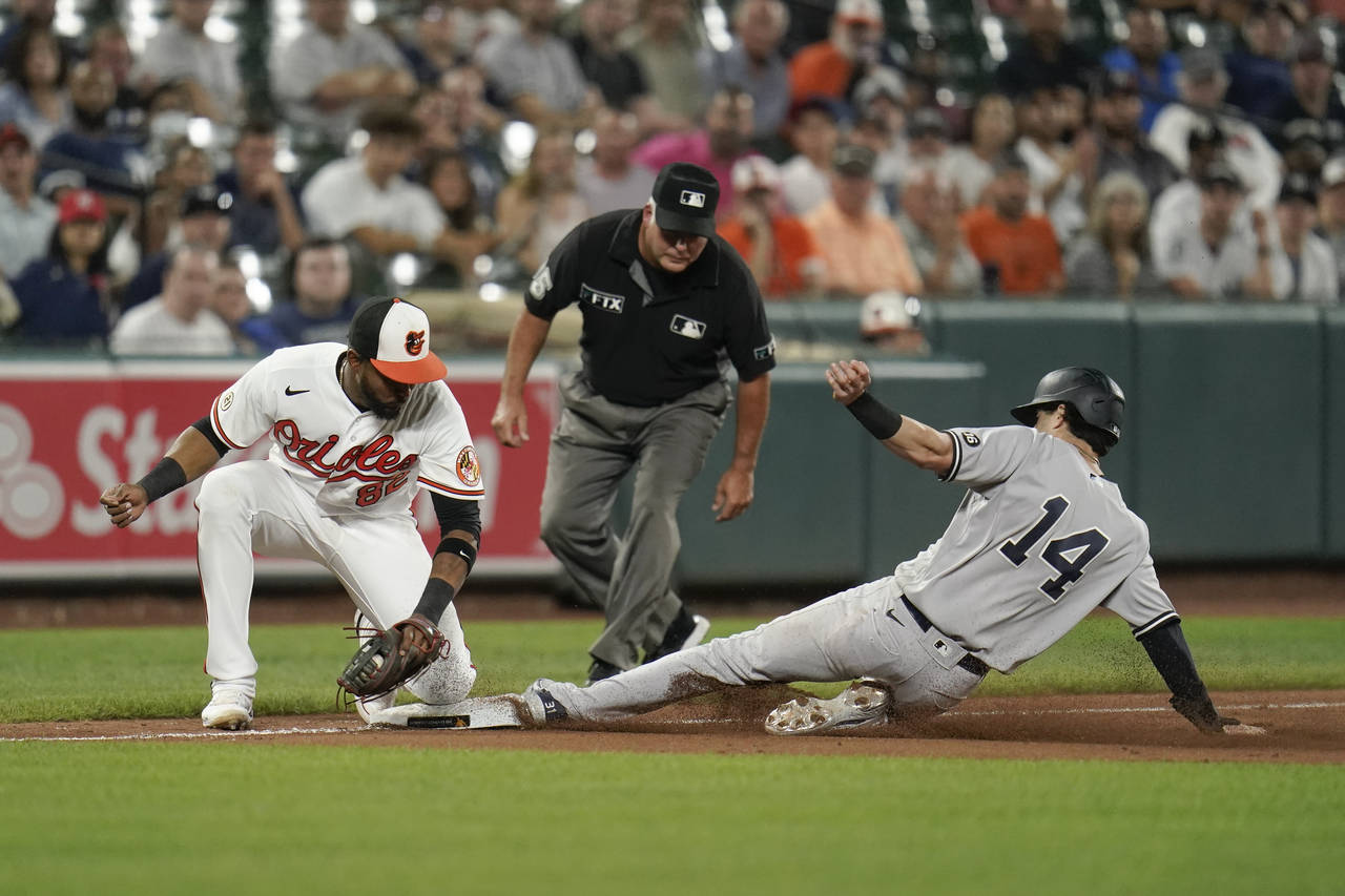 New York Yankees' Tyler Wade, right, steals third base as Baltimore Orioles third baseman Kelvin Gu...