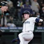 
              Seattle Mariners' Jarred Kelenic, right, begins his slide home to score as Oakland Athletics catcher Sean Murphy waits for the ball in the fourth inning of a baseball game Monday, Sept. 27, 2021, in Seattle. (AP Photo/Elaine Thompson)
            