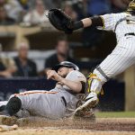 
              San Francisco Giants' Brandon Belt, below, scores off an RBI-single by LaMonte Wade Jr. as San Diego Padres catcher Austin Nola looks on, above, during the ninth inning of a baseball game Tuesday, Sept. 21, 2021, in San Diego. (AP Photo/Gregory Bull)
            