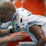 
              A member of the team staff assists Miami Dolphins quarterback Tua Tagovailoa (1) after he left the field injured during the first half of an NFL football game against the Buffalo Bills, Sunday, Sept. 19, 2021, in Miami Gardens, Fla. (AP Photo/Wilfredo Lee)
            