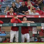 
              Los Angeles Angels manager Joe Maddon, center left, and center fielder Mike Trout, center right, stand in the dugout during the first inning of a baseball game against the Oakland Athletics Friday, Sept. 17, 2021, in Anaheim, Calif. (AP Photo/Ashley Landis)
            