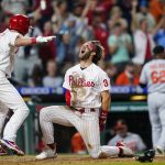 
              Philadelphia Phillies' Bryce Harper (3) and Andrew Knapp (5) celebrate after Harper scored the game-winning run on a two-run triple by J.T. Realmuto during the 10th inning of an interleague baseball game against the Baltimore Orioles, Tuesday, Sept. 21, 2021, in Philadelphia. (AP Photo/Matt Slocum)
            