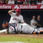 
              Los Angeles Angels' Jack Mayfield, top, is tagged out at home by Houston Astros catcher Martin Maldonado while trying to score after Jose Rojas was safe at first on a fielding error by second baseman Jose Altuve during the sixth inning of a baseball game Thursday, Sept. 23, 2021, in Anaheim, Calif. (AP Photo/Mark J. Terrill)
            