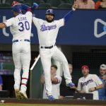 
              Texas Rangers' Nathaniel Lowe (30) and Isiah Kiner-Falefa, right, celebrate after Lowe hit a two-run home run that scored Kiner-Falefa during the first inning of the team's baseball game against the Houston Astros in Arlington, Texas, Tuesday, Sept. 14, 2021. (AP Photo/Tony Gutierrez)
            