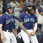 SEATTLE, WASHINGTON - OCTOBER 02: Jake Bauers #5 and J.P. Crawford #3 of the Seattle Mariners react after scoring on a single by Mitch Haniger #17 during the eighth inning against the Los Angeles Angels at T-Mobile Park on October 02, 2021 in Seattle, Washington. (Photo by Steph Chambers/Getty Images)