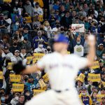 SEATTLE, WASHINGTON - OCTOBER 03: Fans hold signs as Tyler Anderson #31 of the Seattle Mariners pitches during the first inning against the Los Angeles Angels at T-Mobile Park on October 03, 2021 in Seattle, Washington. (Photo by Steph Chambers/Getty Images)