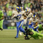SEATTLE, WASHINGTON - OCTOBER 07: Running back Darrell Henderson #27 of the Los Angeles Rams eludes the tackle of safety Jamal Adams #33 of the Seattle Seahawks in the second half at Lumen Field on October 07, 2021 in Seattle, Washington. (Photo by Lindsey Wasson/Getty Images)