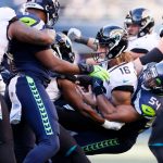 SEATTLE, WASHINGTON - OCTOBER 31: Trevor Lawrence #16 of the Jacksonville Jaguars is hit by Bobby Wagner #54 of the Seattle Seahawks during the fourth quarter at Lumen Field on October 31, 2021 in Seattle, Washington. (Photo by Steph Chambers/Getty Images)