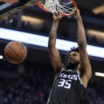 
              Sacramento Kings forward Marvin Bagley III hangs from the rim after dunking against the Utah Jazz during the first quarter of an NBA basketball game in Sacramento, Calif., Friday, Oct. 22, 2021. (AP Photo/Jose Luis Villegas)
            