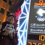 
              A supporter of the 2022 Beijing Winter Olympics poses for photos with a countdown clock as it crosses into the 100 days countdown to the opening of the Winter Olympics in Beijing, China, Tuesday, Oct. 26, 2021. (AP Photo/Ng Han Guan) ///
            