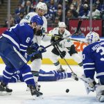 
              San Jose Sharks forward Nick Bonino (13) is defended by Toronto Maple Leafs defenseman Jake Muzzin (8) after Maple Leafs goaltender Michael Hutchinson (30) gave up a rebound during the first period of an NHL hockey game Friday, Oct. 22, 2021, in Toronto. (Evan Buhler/The Canadian Press via AP)
            