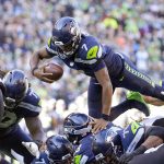 
              Seattle Seahawks quarterback Geno Smith leaps up and over the line of scrimmage to score a touchdown against the Jacksonville Jaguars during the first half of an NFL football game, Sunday, Oct. 31, 2021, in Seattle. (AP Photo/Stephen Brashear)
            