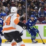 
              Vancouver Canucks' Justin Bailey, back right, looks to pass the puck during the second period of the team's NHL hockey game against the Philadelphia Flyers on Thursday, Oct. 28, 2021, in Vancouver, British Columbia. (Darryl Dyck/The Canadian Press via AP)
            