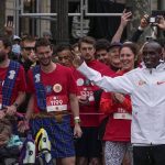 
              Kenyan marathon legend Eliud Kipchoge, right, poses before the start with the runners of the 5 kms (3,125 mils) "Marathon for all Paris 24" at the Champs Elysees avenue in Paris, Sunday, Oct. 31, 2021. Over 3'600 amateur runners faced off Sunday against Kenyan marathon legend Eliud Kipchoge in a special race in the heart of Paris, as the city prepares to host the 2024 Olympics. All those he fails to catch over the 5-kilomter race will win access to an Olympic-related marathon in 2024. (AP Photo/Michel Euler)
            