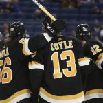 
              Boston Bruins center Charlie Coyle (13) celebrates with teammates Erik Haula (56) and Craig Smith (12) after his goal during the second period of an NHL hockey game against the Buffalo Sabres, Friday, Oct. 22, 2021, in Buffalo, N.Y. (AP Photo/Joshua Bessex)
            