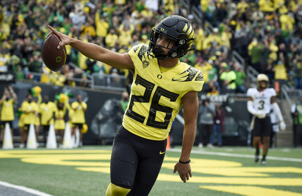 Oregon running back Travis Dye (26) celebrates a touchdown during the second quarter of an NCAA col...