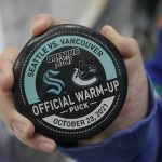 
              A fan holds an official warm-up puck before an NHL hockey game between the Seattle Kraken and the Vancouver Canucks, Saturday, Oct. 23, 2021, in Seattle. (AP Photo/Ted S. Warren)
            