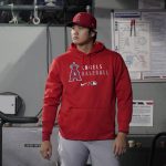 
              Los Angeles Angels' Shohei Ohtani stands in the dugout before a baseball game against the Seattle Mariners, Sunday, Oct. 3, 2021, in Seattle. (AP Photo/Ted S. Warren)
            