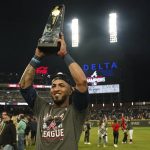 
              Atlanta Braves left fielder Eddie Rosario holds the Most Valuable Player trophy after winning Game 6 of baseball's National League Championship Series against the Los Angeles Dodgers Sunday, Oct. 24, 2021, in Atlanta. The Braves defeated the Dodgers 4-2 to win the series. (AP Photo/Brynn Anderson)
            