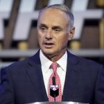 
              FILE - In this July 11, 2021, file photo, Major League Baseball Commissioner Rob Manfred kicks off the first round of the 2021 MLB baseball draft in Denver. As the World Series shifts to Atlanta, some TV viewers may be offended to see Braves fans still chopping and chanting. After teams in the NFL and Major League Baseball have dropped names viewed as offensive to Native Americans the last two years, the Braves chop on. The tomahawk chop has the support of baseball commissioner Rob Manfred.  (AP Photo/David Zalubowski, File)
            