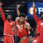 
              The Houston Rockets bench signals three after the three-point basket by center Christian Wood (35) during the first half of an NBA basketball game against the Oklahoma City Thunder, Friday, Oct. 22, 2021, in Houston. (AP Photo/Michael Wyke)
            