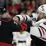 
              Chicago Blackhawks center Reese Johnson (52) and Carolina Hurricanes defenseman Tony DeAngelo (77) fight during the third period of an NHL hockey game Friday, Oct. 29, 2021, in Raleigh, N.C. Both players were penalized for fighting. (AP Photo/Chris Seward)
            