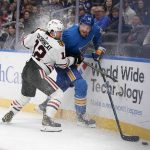 
              Chicago Blackhawks' Alex DeBrincat (12) and St. Louis Blues' Colton Parayko (55) chase after a loose puck along the boards during the first period of an NHL hockey game Saturday, Oct. 30, 2021, in St. Louis. (AP Photo/Jeff Roberson)
            