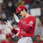 
              Los Angeles Angels' Shohei Ohtani claps his hands together as he crosses home on his solo home run against the Seattle Mariners in the first inning of a baseball game Sunday, Oct. 3, 2021, in Seattle. (AP Photo/Elaine Thompson)
            