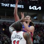 
              Detroit Pistons forward Kelly Olynyk, top, drives to the basket against Chicago Bulls forward DeMar DeRozan during the first half of an NBA basketball game in Chicago, Saturday, Oct. 23, 2021. (AP Photo/Nam Y. Huh)
            