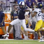
              TCU wide receiver Quentin Johnston (1) stiff-arms West Virginia safety Sean Mahone (29) after making a catch for a first down during the first half of an NCAA college football game Saturday, Oct. 23, 2021, in Fort Worth, Texas. (AP Photo/Ron Jenkins)
            