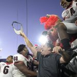 
              Georgia head coach Kirby Smart, center, celebrates with players and fans in the stands after they defeated Florida in an NCAA college football game, Saturday, Oct. 30, 2021, in Jacksonville, Fla. (AP Photo/Phelan M. Ebenhack)
            
