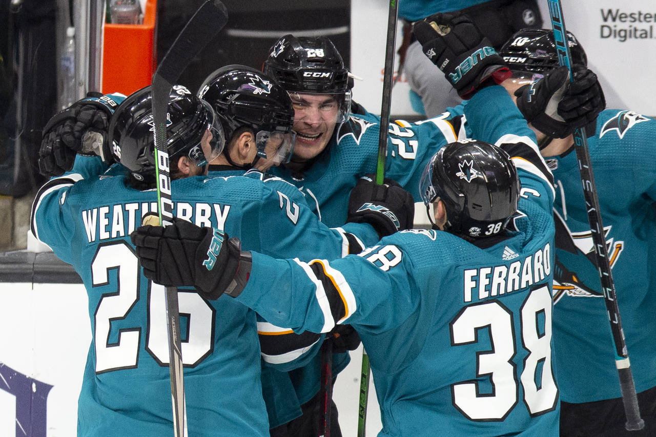 San Jose Sharks right wing Timo Meier, center, is mobbed by his teammates after his overtime goal a...