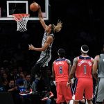 
              Washington Wizards' Montrezl Harrell (6) and Kentavious Caldwell-Pope (1) watch as Brooklyn Nets' Nic Claxton (33) dunks during the first half of an NBA basketball game Monday, Oct. 25, 2021, in New York. (AP Photo/Frank Franklin II)
            