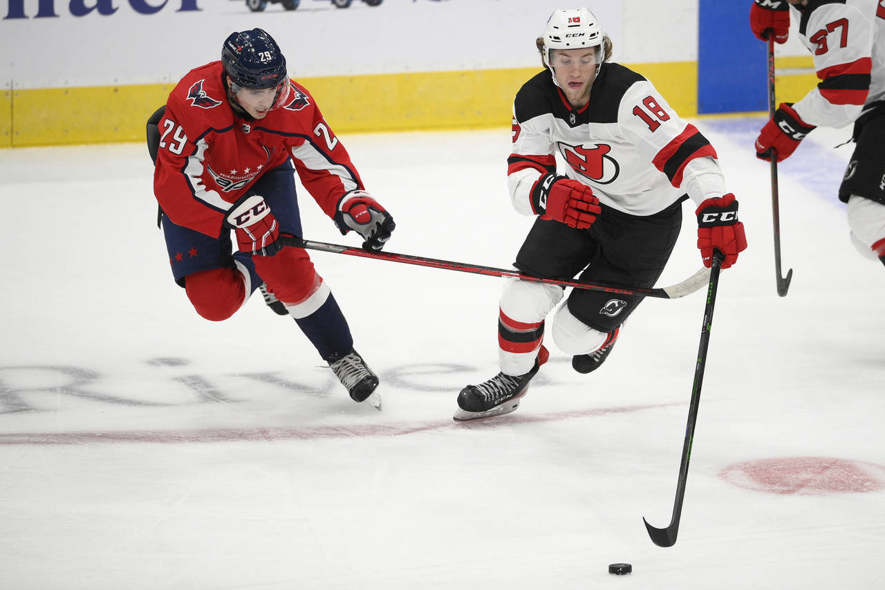 New Jersey Devils forward Dawson Mercer (18) skates with the puck ahead of Washington Capitals cent...