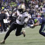 
              New Orleans Saints' Alvin Kamara runs for a touchdown after a pass reception as Seattle Seahawks' Ryan Neal defends during the first half of an NFL football game, Monday, Oct. 25, 2021, in Seattle. (AP Photo/John Froschauer)
            