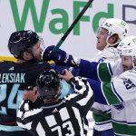 
              Vancouver Canucks' Oliver Ekman-Larsson (23) and Brock Boeser (6) move in to scuffle with Seattle Kraken's Jamie Oleksiak during the first period of an NHL hockey game Saturday, Oct. 23, 2021, in Seattle. (AP Photo/Elaine Thompson)
            