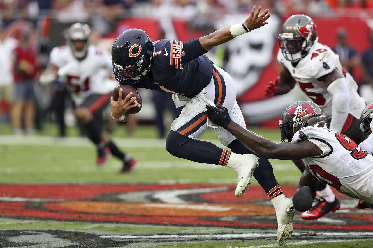 Chicago Bears quarterback Justin Fields (1) gets tripped up by Tampa Bay Buccaneers outside linebac...