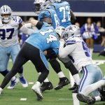 
              Carolina Panthers quarterback Sam Darnold (14) is sacked by Dallas Cowboys defensive end Randy Gregory (94) as defensive tackle Osa Odighizuwa (97) looks on in the first half of an NFL football game in Arlington, Texas, Sunday, Oct. 3, 2021. (AP Photo/Michael Ainsworth)
            