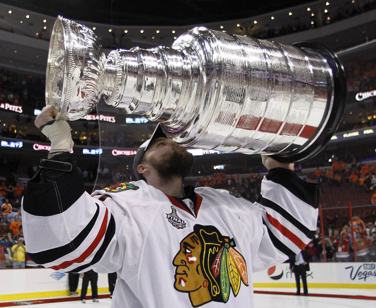 FILE - Chicago Blackhawks goalie Antti Niemi of Finland kisses the Stanley Cup on the ice after the...