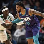 
              Charlotte Hornets forward Miles Bridges (0) is guarded by Boston Celtics guard Dennis Schroder, left, during the first half of an NBA basketball game in Charlotte, N.C., Monday, Oct. 25, 2021. (AP Photo/Jacob Kupferman)
            