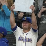 
              Seattle Mariners third baseman Kyle Seager holds up third base after it was given to him when he was subbed out of a baseball game against the Los Angeles Angels during the ninth inning, Sunday, Oct. 3, 2021, in Seattle. (AP Photo/Ted S. Warren)
            