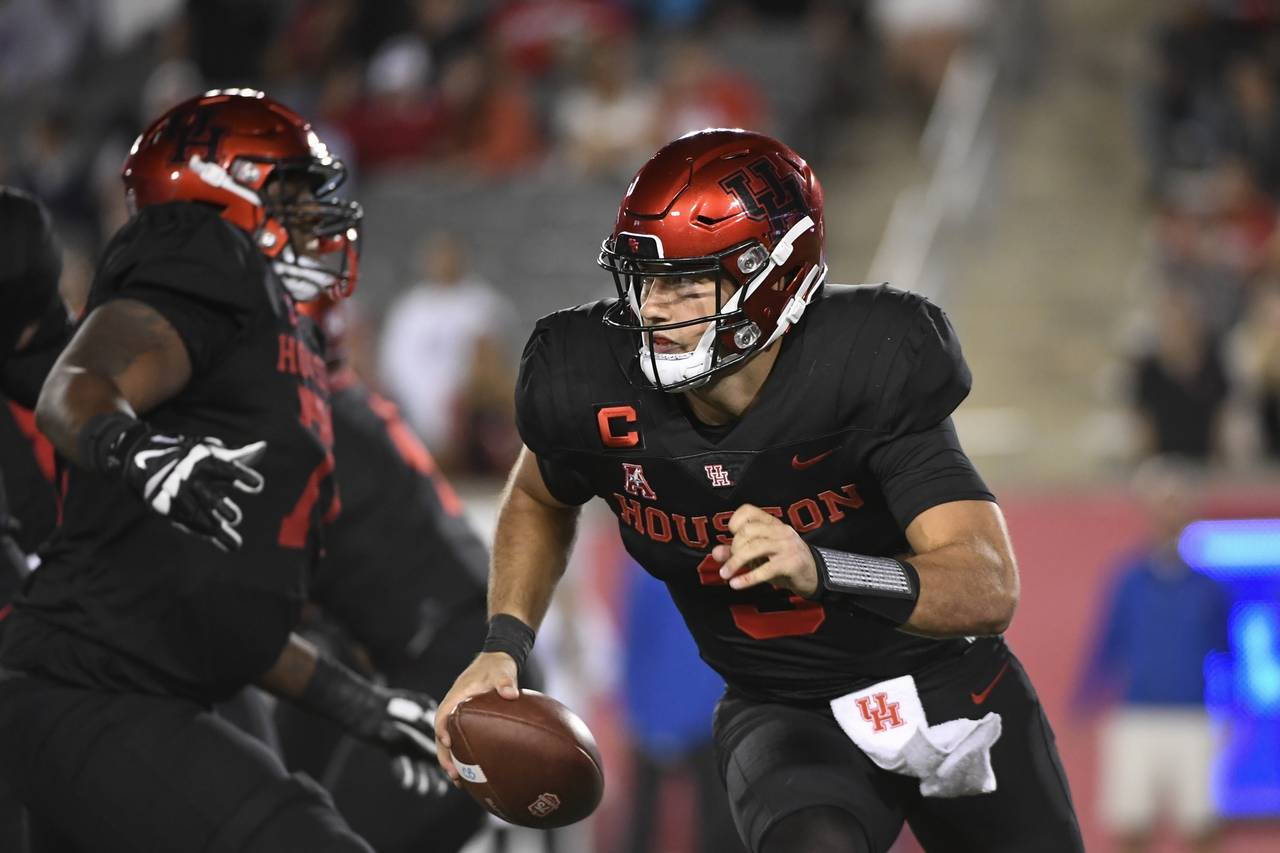 Houston quarterback Clayton Tune (3) runs the ball against SMU during the first half of an NCAA col...