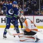 
              Philadelphia Flyers goalie Martin Jones (35) makes a save as Vancouver Canucks' Tanner Pearson (70) watches during the second period of an NHL hockey game Thursday, Oct. 28, 2021, in Vancouver, British Columbia. (Darryl Dyck/The Canadian Press via AP)
            