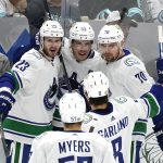 
              Vancouver Canucks' Bo Horvat (53) is congratulated by teammates after scoring against the Seattle Kraken durihng the second period of an NHL hockey game Saturday, Oct. 23, 2021, in Seattle. (AP Photo/Elaine Thompson)
            