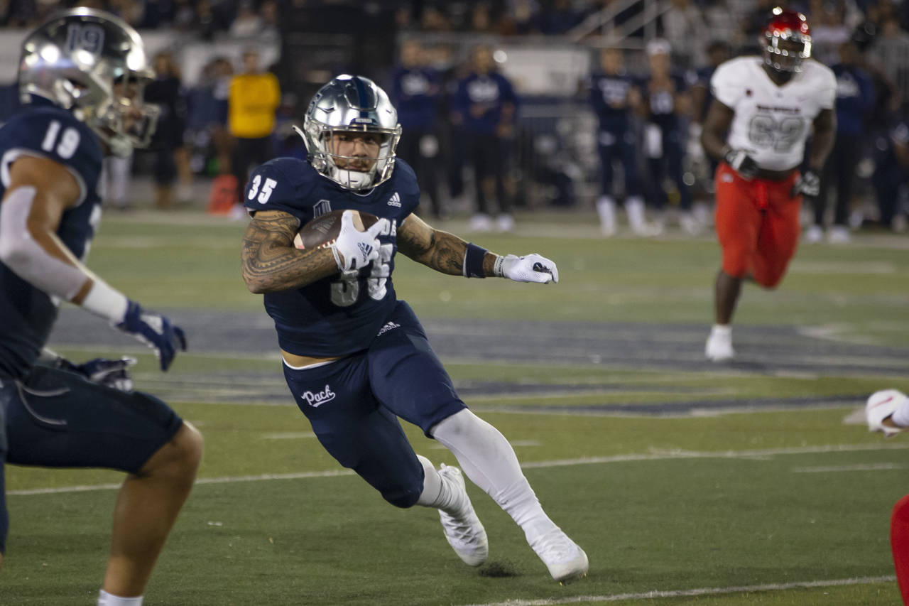 Nevada running back Toa Taua (35) carries against UNLV during the first half of an NCAA college foo...