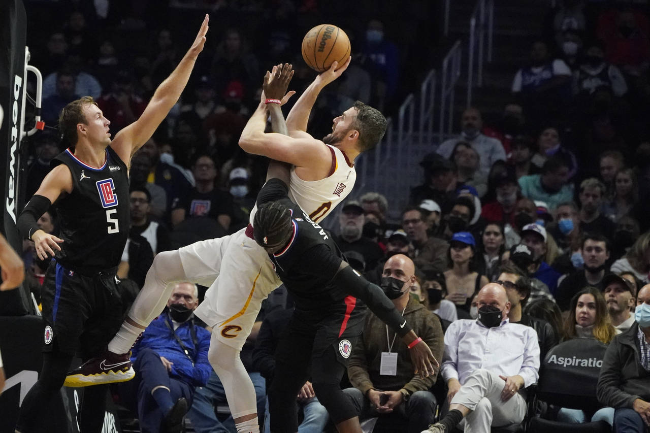 Cleveland Cavaliers forward Kevin Love, center, shoots between Los Angeles Clippers guard Luke Kenn...
