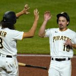 
              Pittsburgh Pirates' Bryan Reynolds (10) and Cole Tucker celebrate after scoring on a double by Michael Chavis off Cincinnati Reds relief pitcher Justin Wilson during the fifth inning of a baseball game in Pittsburgh, Saturday, Oct. 2, 2021. (AP Photo/Gene J. Puskar)
            