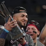 
              Atlanta Braves left fielder Eddie Rosario holds the Most Valuable Player trophy after winning Game 6 of baseball's National League Championship Series against the Los Angeles Dodgers Sunday, Oct. 24, 2021, in Atlanta. The Braves defeated the Dodgers 4-2 to win the series. (AP Photo/Ashley Landis)
            