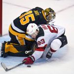 
              New Jersey Devils' Jesper Bratt (63) collides with Pittsburgh Penguins goaltender Tristan Jarry (35) during the third period of an NHL hockey game in Pittsburgh, Saturday, Oct. 30, 2021. A penalty shot was awarded on the play, with Bratt scoring the go-ahead goal. The Devils won 4-2. (AP Photo/Gene J. Puskar)
            